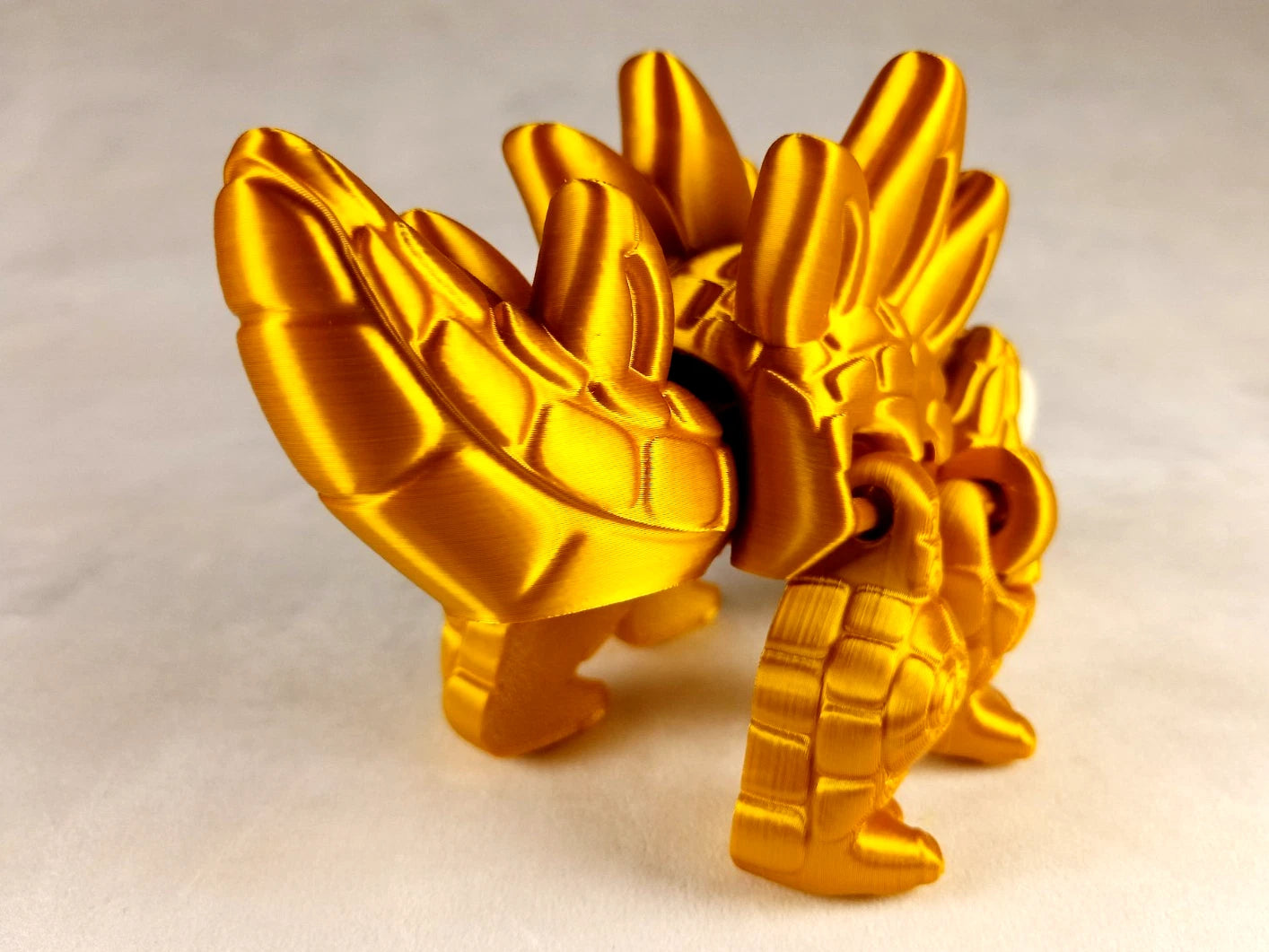 Stegosaurus Flexi Dinosaur, Dinosauro articolato Oro seta stampa 3D a colori PLA lunghezza 16 cm.